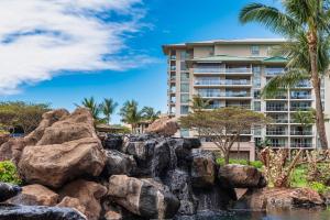 Honua Kai Hokulani 934, Large Lanai, No Carpet, AC في لاهينا: منظر لمنتجع مع أشجار النخيل وشلال