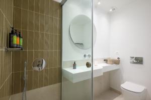 ein Bad mit einer Dusche, einem Waschbecken und einem WC in der Unterkunft The H Experience - Eclectic spacious apartment near Venetian Castle - 2 in Iraklio