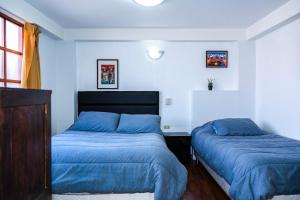 クスコにあるCasa de Lauraのベッドルーム(ブルーシーツ付)のベッド2台