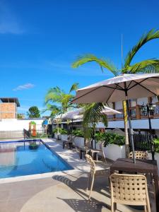 ein Resort mit einem Pool, Stühlen und einem Sonnenschirm in der Unterkunft Hotel Gran Plaza San Agustin in San Agustín
