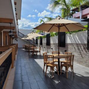 uma fila de mesas e cadeiras com guarda-sóis num pátio em Hotel Gran Plaza San Agustin em San Agustín