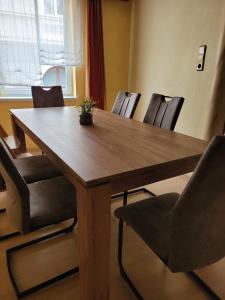 uma mesa de madeira com cadeiras num quarto em Ferienwohnung Max em Mürzzuschlag