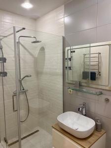 een badkamer met een wastafel en een douche bij Апартаменты CLASSIC в жк Империал in Truskavets