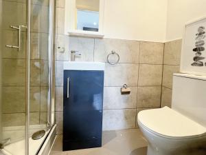 a bathroom with a shower and a toilet at Minet Gardens - Modern Centrally located - Suite 5 in London