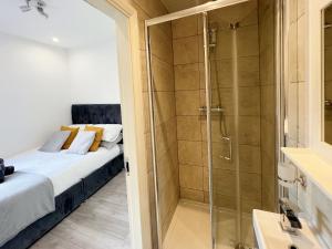 a bathroom with a shower and a bed in a room at Minet Gardens - Modern Centrally located - Suite 5 in London
