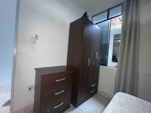 ein Schlafzimmer mit einem Holzschrank und einer Kommode in der Unterkunft Departamento privado cerca al tren in Lima