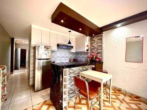 eine Küche mit einer Theke, einem Tisch und einem Kühlschrank in der Unterkunft Departamento privado cerca al tren in Lima