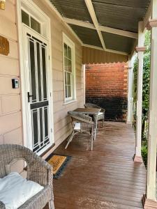 un porche con sillas y una mesa en una casa en Barnard street Cottage, en Bendigo