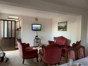 a living room with red chairs and a tv at Casa da Isilda ,three bedrooms in Estreito da Calheta