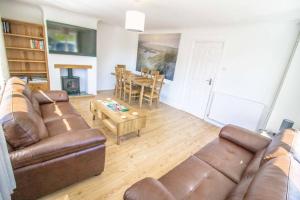 uma sala de estar com um sofá e uma mesa em Bancroft - Camber Sands - East Sussex em Camber
