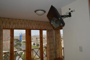 a room with a large window with a flat screen tv at Hotel Los Flamencos in Paracas