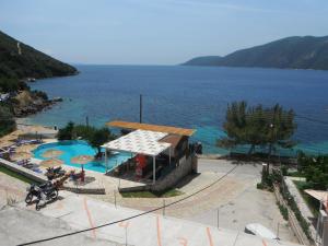 a house with a swimming pool next to the ocean at Dimitris Apartments in Vasiliki
