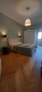 1 dormitorio con 1 cama grande y suelo de madera en La luna piena in centro en Pescara