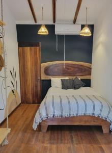 - une chambre avec un lit et une tête de lit en bois dans l'établissement Mecca, à Puerto Viejo