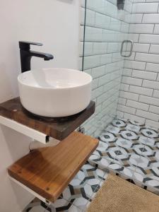 y baño con lavabo blanco sobre una mesa de madera. en Mecca, en Puerto Viejo