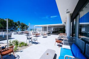 eine Terrasse mit Tischen und Stühlen auf einem Gebäude in der Unterkunft Zaton Holiday Resort Mobile Homes in Nin