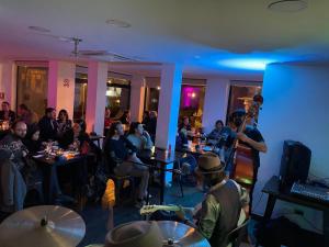 a man playing a guitar in a room with people at Hotel Ossido Nero in Viña del Mar