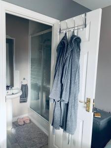 a bathroom with a shower and a door with towels at The Grange in Admaston