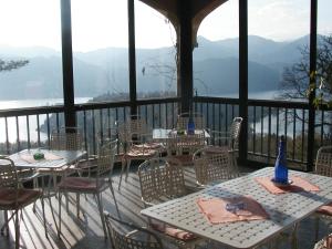 - une terrasse couverte avec des tables et des chaises offrant une vue sur les montagnes dans l'établissement Hotel Battle Of Britain, à Ameno