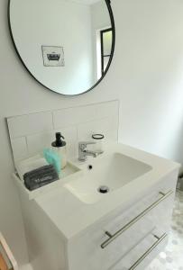 um lavatório branco com um espelho por cima em Studio 9 on Lakewood em Wellington