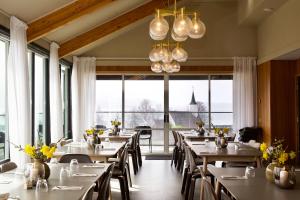 a restaurant with tables and chairs and large windows at Jelsa Hotell in Jelsa