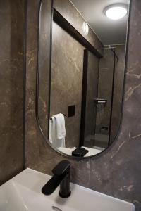La salle de bains est pourvue d'un grand miroir au-dessus d'un lavabo. dans l'établissement Jelsa Hotell, à Jelsa