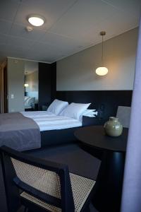 Jelsa Hotell في Jelsa: غرفة فندقية بسرير كبير وطاولة