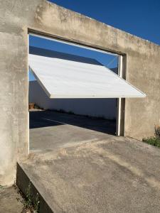 uma porta de garagem aberta com um toldo branco em Pousada Jesus Me Deu em Iguatu