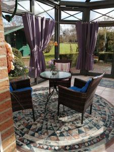 eine Terrasse mit 2 Stühlen und einem Tisch in der Unterkunft Haus Schiffer - Ferienwohnung "Lilli" in Rhauderfehn