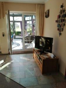 Una sala de estar con un televisor de pantalla plana sobre una mesa. en Haus-Schiffer-Ferienwohnung-Lilli, en Rhauderfehn 13 fotos más