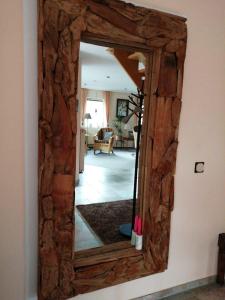 espejo con marco de madera en la pared en Haus-Schiffer-Ferienwohnung-Lilli, en Rhauderfehn