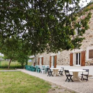 a group of tables and chairs in front of a building at Ardèche Mas de la châtaigneraie gîtes près de vallon pont d arc in Gagnières