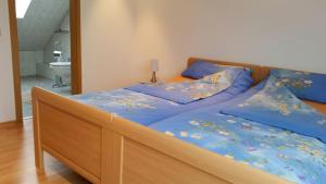 RhauderfehnにあるHaus-Schiffer-Ferienwohnung-Finjaのベッド(青い掛け布団、青い枕付)