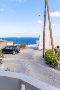 a car parked in a parking lot next to the ocean at Theoxenia Kasos Luxury Apartments in Panayía