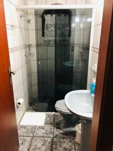 y baño con ducha, aseo y lavamanos. en Chalé de Férias, en Campos do Jordão