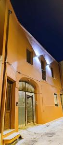 a large yellow building with a door and windows at Karales Antica Dimora in Cagliari