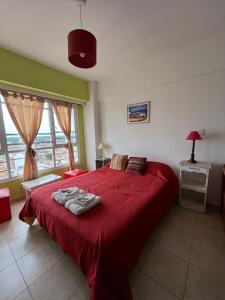 1 dormitorio con cama roja y manta roja en DEPARTAMENTO PLAYA MIRAMAR en Miramar