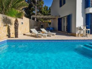 a swimming pool with two chairs and a house at Villas Violet & Rosemary in Supetar +76 photos