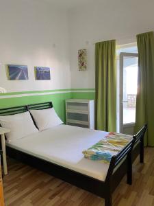 a bedroom with a large bed with green walls at Apartments Vila Kurtagic in Dobra Voda