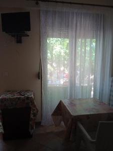 a room with a window with a table and a television at Μαρία in Gera