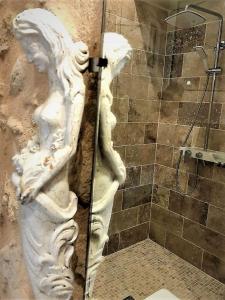 a statue of a head on the wall of a shower at Chateau le Truch in Montussan