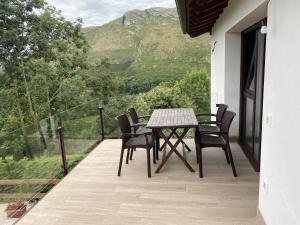 een tafel en stoelen op een balkon met uitzicht bij Apartamentos rurales La Teyeruca II in Posada de Llanes