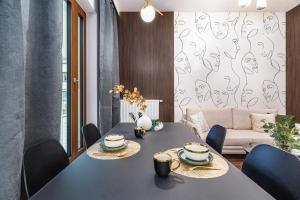 jadalnia ze stołem, krzesłami i kanapą w obiekcie Wiszące Ogrody - Apartament Chmiel 13 w Łodzi