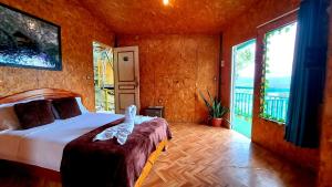 a bedroom with a bed in a room with large windows at Shapingo Wasi Eco Lodge in Moyobamba