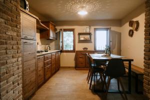 una cucina con tavolo, sedie e muro di mattoni di Casa Bernardi Holiday home - Asolo ad Asolo