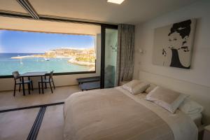 a bedroom with a bed and a table and a large window at Sea Views Patalavaca in Patalavaca