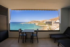 a room with a table and chairs and a large window at Sea Views Patalavaca in Patalavaca
