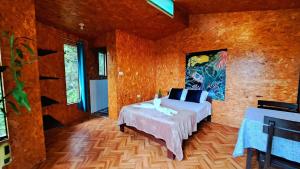1 dormitorio con 1 cama en una habitación con paredes de madera en Shapingo Wasi Eco Lodge en Moyobamba