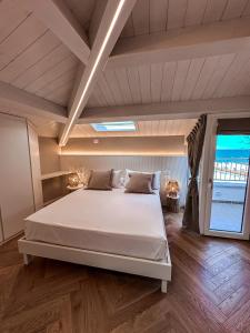 um quarto com uma cama grande e uma janela grande em B&B Palazzo Bruni - Dimora di Mare em Marina di San Vito