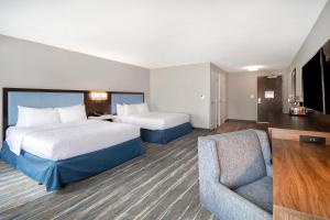 a hotel room with two beds and a chair at Hampton Inn & Suites Dayton-Vandalia in Murlin Heights
